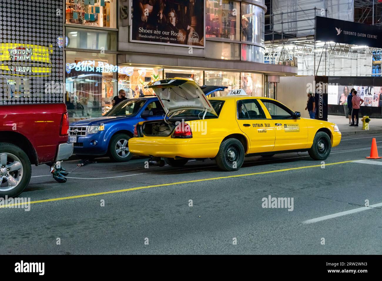 Ein gelbes Taxi, das Gothan Taxi vor der Tür liest, ist in der Yonge Street geparkt. Stockfoto