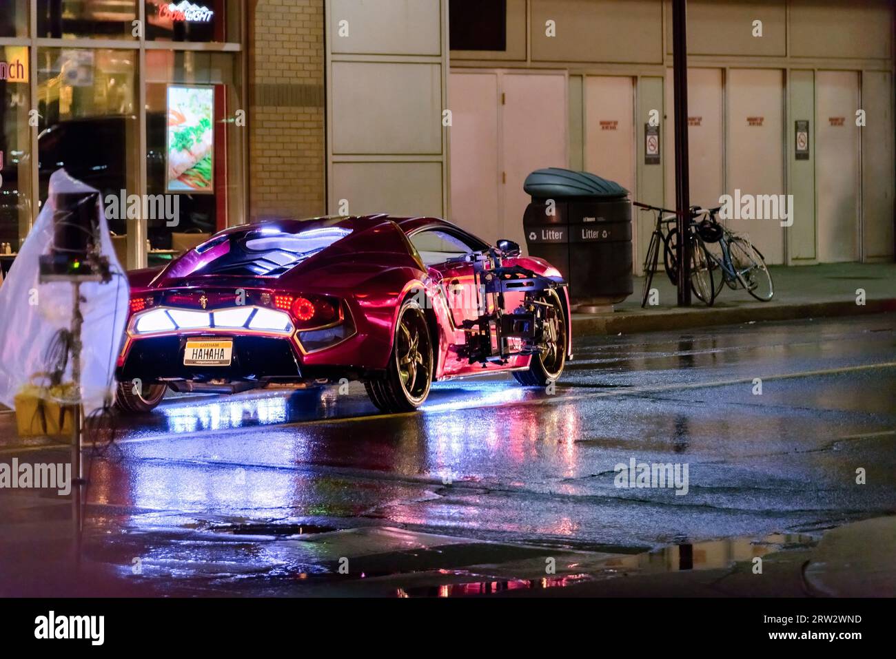 Ein Gothan City-Auto mit Beleuchtung im unteren Teil, damit das Licht auf dem nassen Bürgersteig der Yonge Street reflektiert wird. Stockfoto