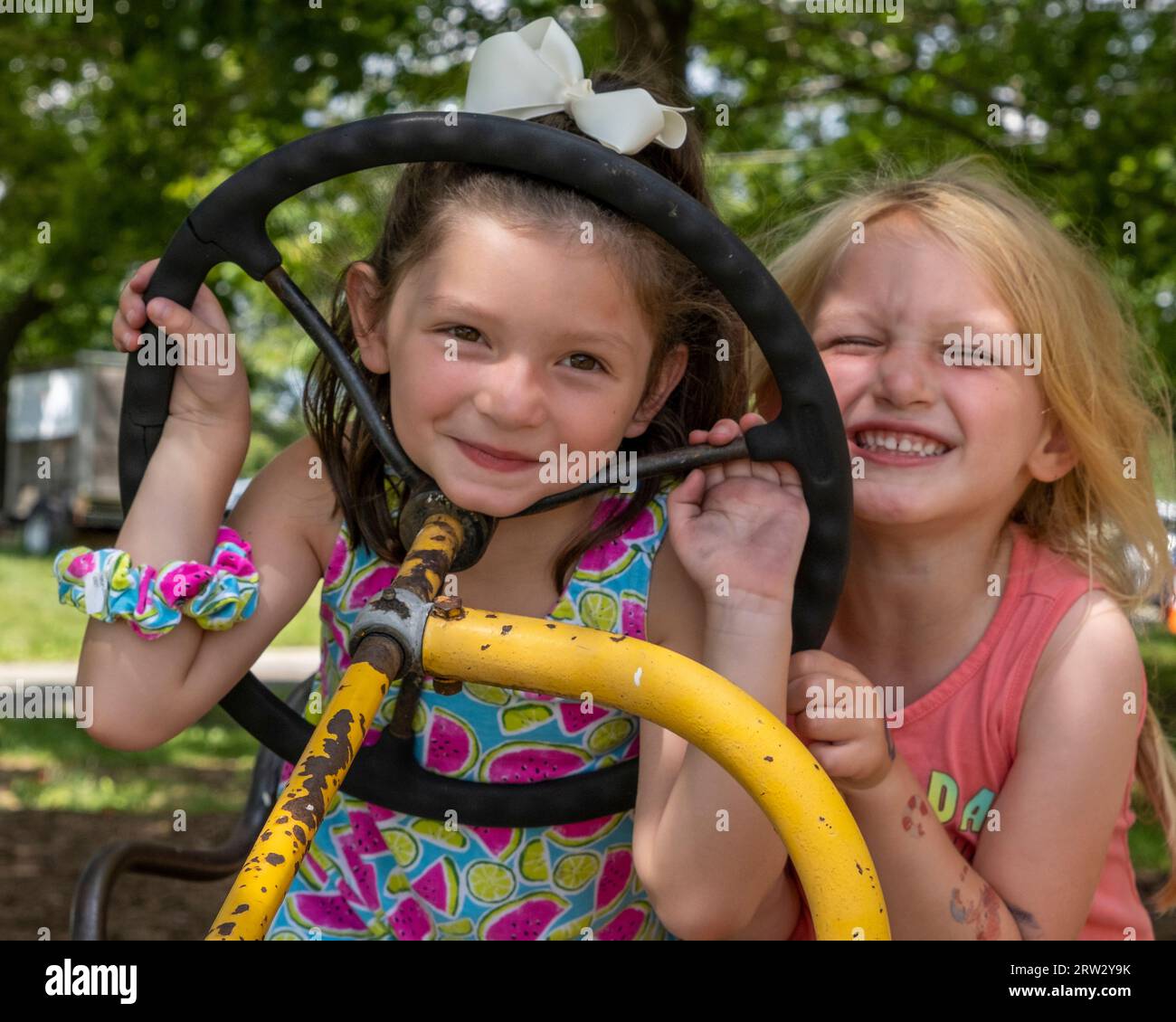 Zwei Mädchen, die sich auf einem Traktor Vergnügen Stockfoto