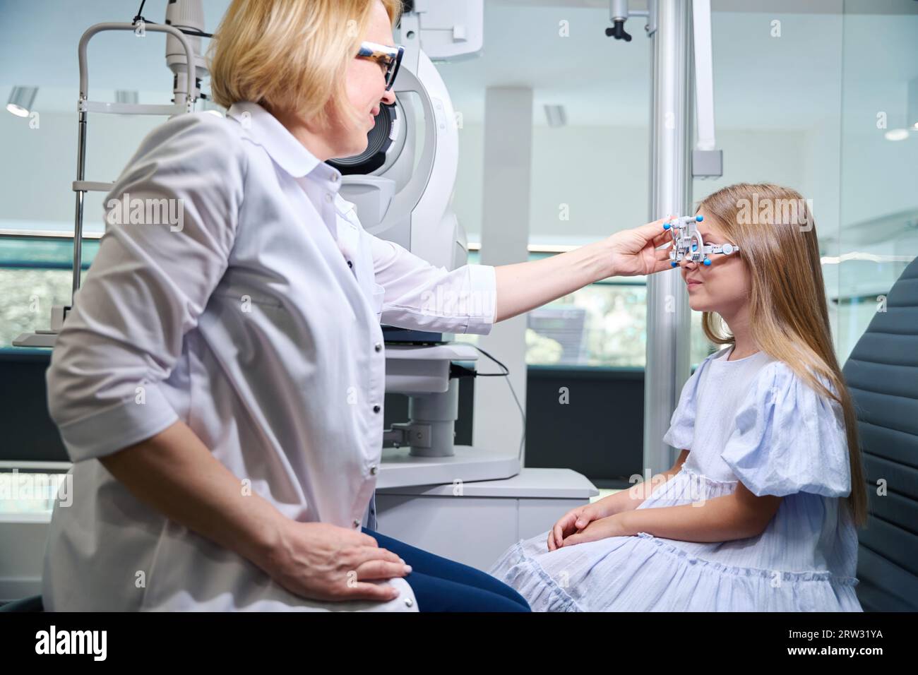 Optometrist zur Beurteilung von Stärke und Astigmatisachse bei kleinen Mädchen Stockfoto