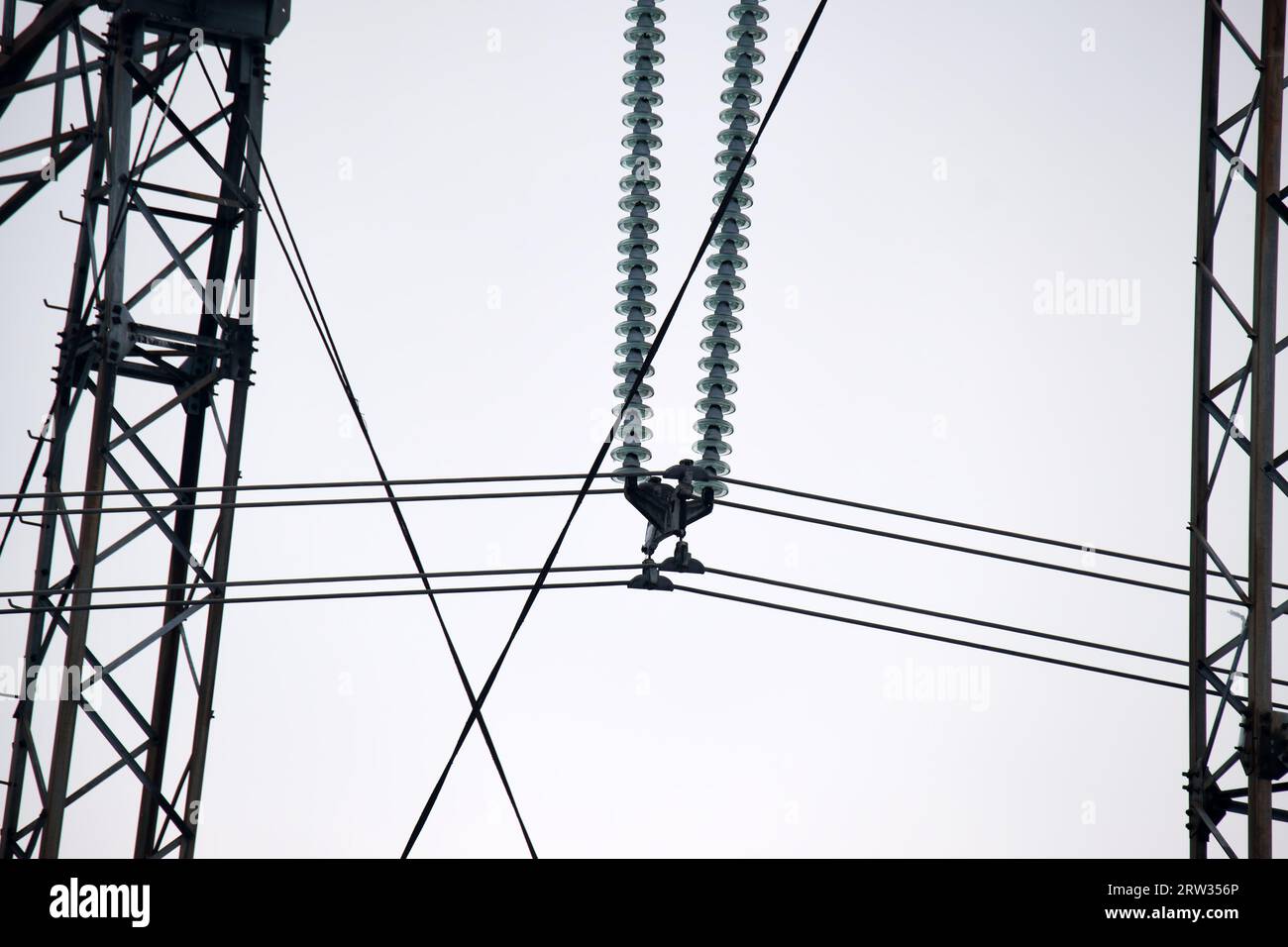 Hochspannungsturm mit elektrischen Stromleitungen, die durch eine sichere Schutzbuchse geteilt werden, wodurch die elektrische Energie sicher durch Kabeldrähte übertragen wird. Strom Stockfoto