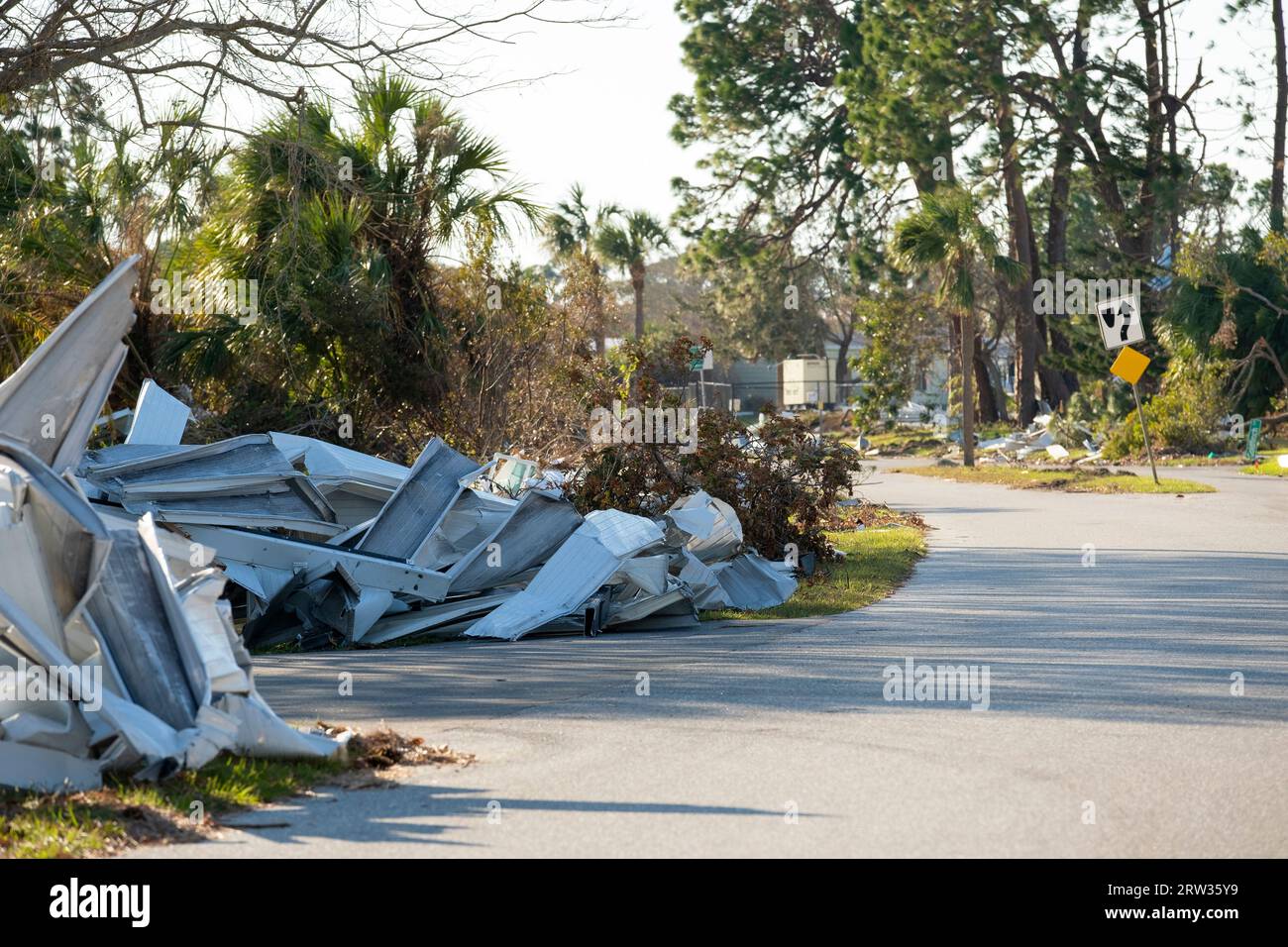 Müllhaufen auf der Straßenseite von stark beschädigten Häusern nach dem Hurrikan in Florida Wohnmobilgebiet. Folgen von Naturkatastrophen Stockfoto
