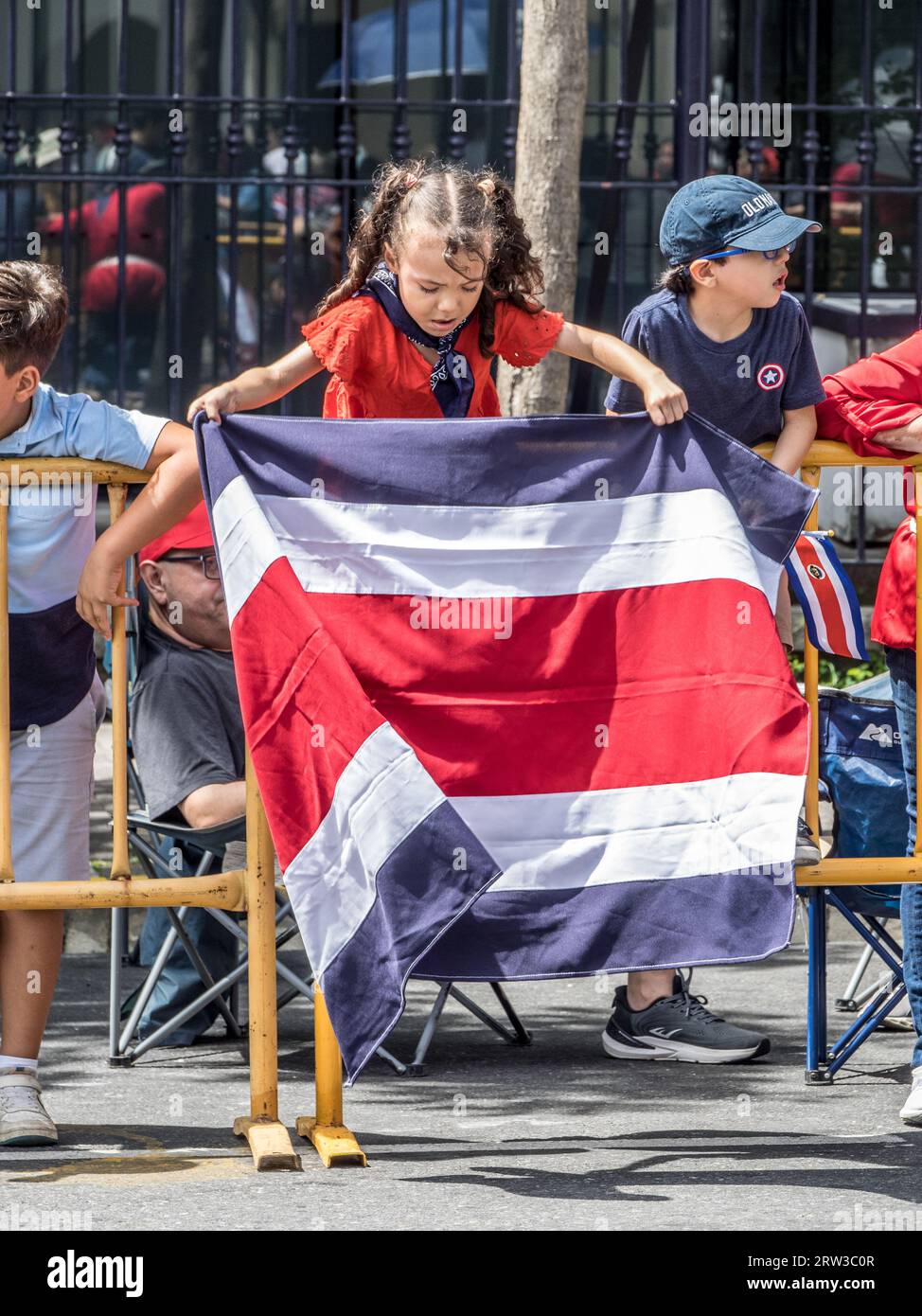 Junge Mädchen entfaltet eine Flagge Costa Ricas während einer Parade zum Unabhängigkeitstag in San José. Stockfoto