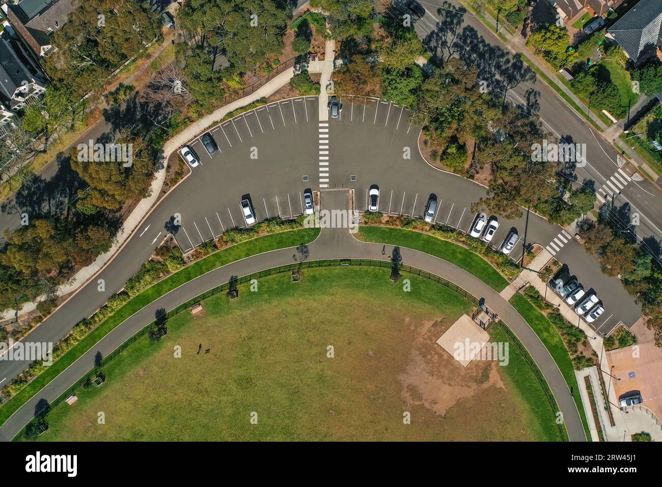 Blick aus der Vogelperspektive auf einen gebogenen Parkplatz und Fußgängerübergänge in der Nähe eines Hundeparks in Sydney, Australien Stockfoto