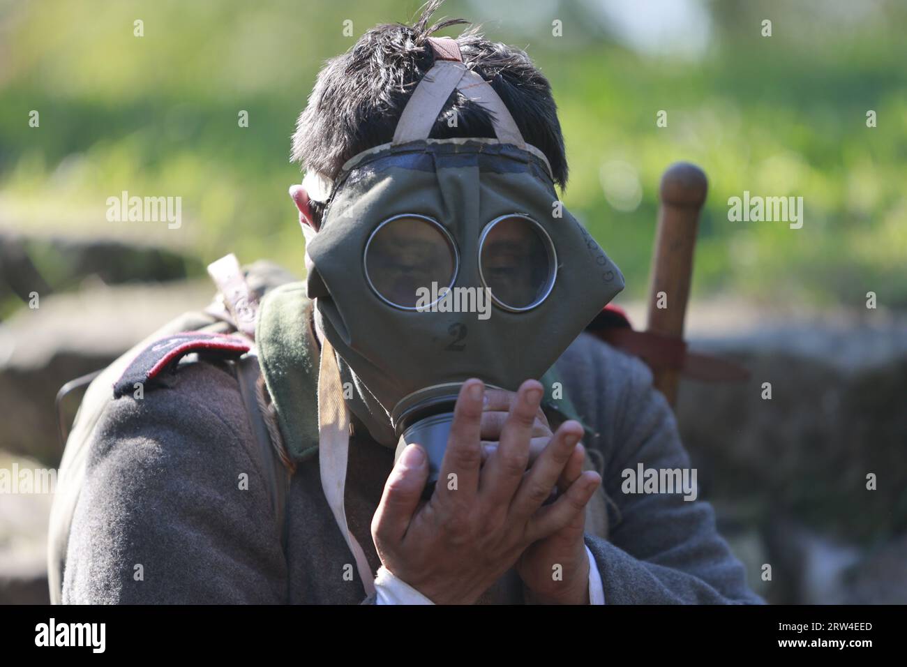 16. September 2023, Sachsen-Anhalt, Halberstadt: Ein historischer Reenaktor legt in der Medingschanze eine Gasmaske an. Besucher erfahren mehr über historische Touren durch die Gräben des Ersten Weltkriegs. Die Medingschanze, wohl der einzige erhaltene Schaugraben aus der Zeit des 1. Weltkriegs auf deutschem Boden, kann bei organisierten Führungen in den Spiegelsbergen besichtigt werden. Die Stadt Halberstadt war seit 1623 Garnisonsstadt und entwickelte sich im Laufe der Jahrhunderte zu einer der bedeutendsten in Mitteldeutschland. Diese lange Zeit der militärischen Präsenz, die erst 1993 mit dem Rückzug der sowjetischen Armee endete, hat zahlreiche regionale Hintergründe hinterlassen Stockfoto