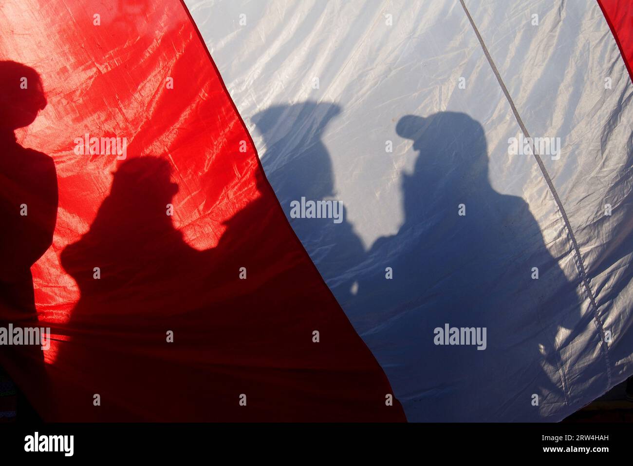 Lima, Peru. September 2023. Silhouette der Demonstranten, die durch eine peruanische Flagge gesehen wurden, als Tausende von Demonstranten erneut gegen die Regierung von Dina Boluarte und den peruanischen Kongress auf die Straße gingen, nachdem sie kürzlich versucht hatten, das nationale Juristenkomitee (JNJ) zu entlassen und die journalistische Berichterstattung über politische Demonstrationen zu verfolgen und zu kriminalisieren. Quelle: Fotoholica Press Agency/Alamy Live News Stockfoto