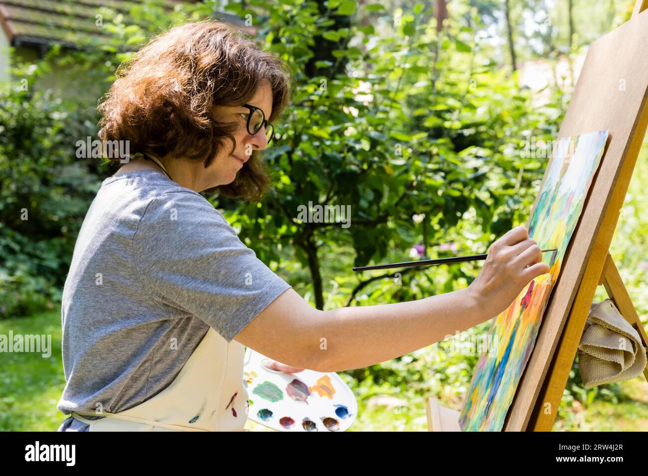 Frau malte auf einer Leinwand mit Pinsel, Frau malte auf einer Leinwand mit Pinsel Stockfoto