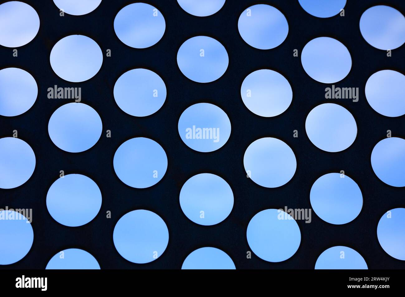 Kühlergrill mit runden Vertiefungen, blauer Himmel im Hintergrund Stockfoto