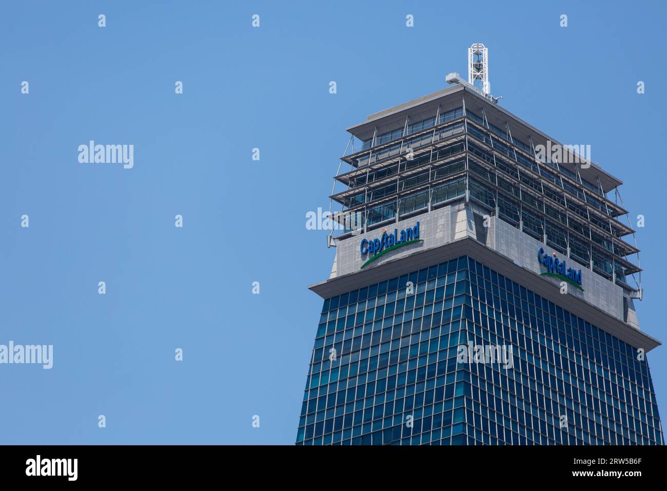 Dieser Wolkenkratzer ist ein 52-stöckiges Bürogebäude der Klasse A im zentralen Geschäftsviertel Singapurs und bietet einen Blick auf die Spitze des Capital Tower vor dem blauen Himmel Stockfoto