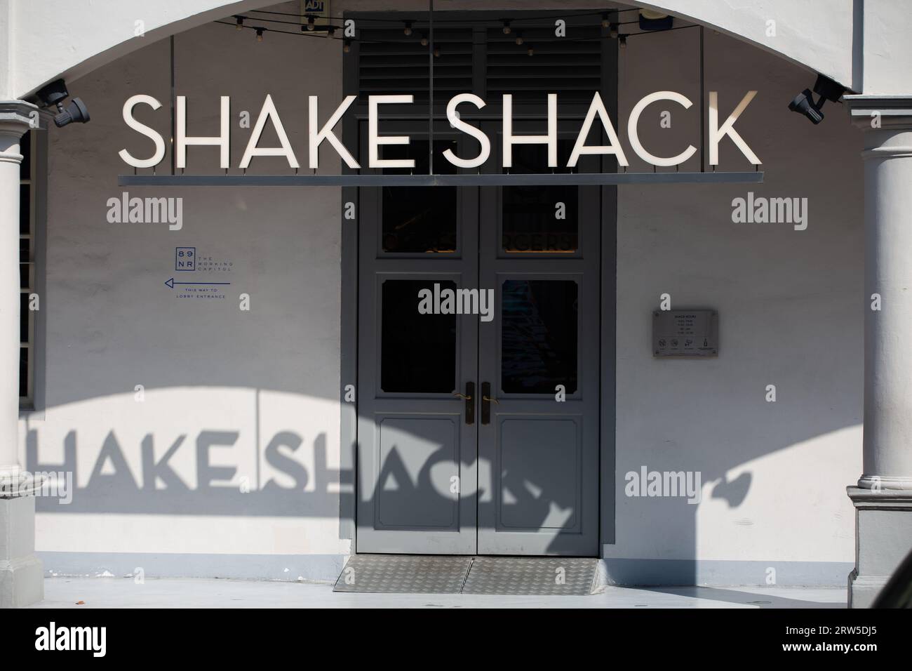 Shack Establishment-Beschilderung. Die Nachmittagsbeleuchtung verleiht der Marke einen interessanten Schlagschatten im weißen Hintergrund. Singapur. Stockfoto