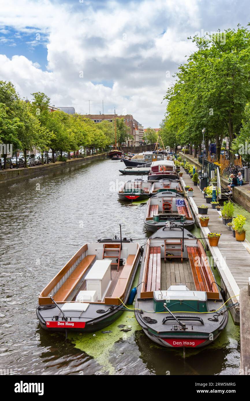 Touristenboote an der Anlegestelle im Kanal in den Haag, Niederlande Stockfoto