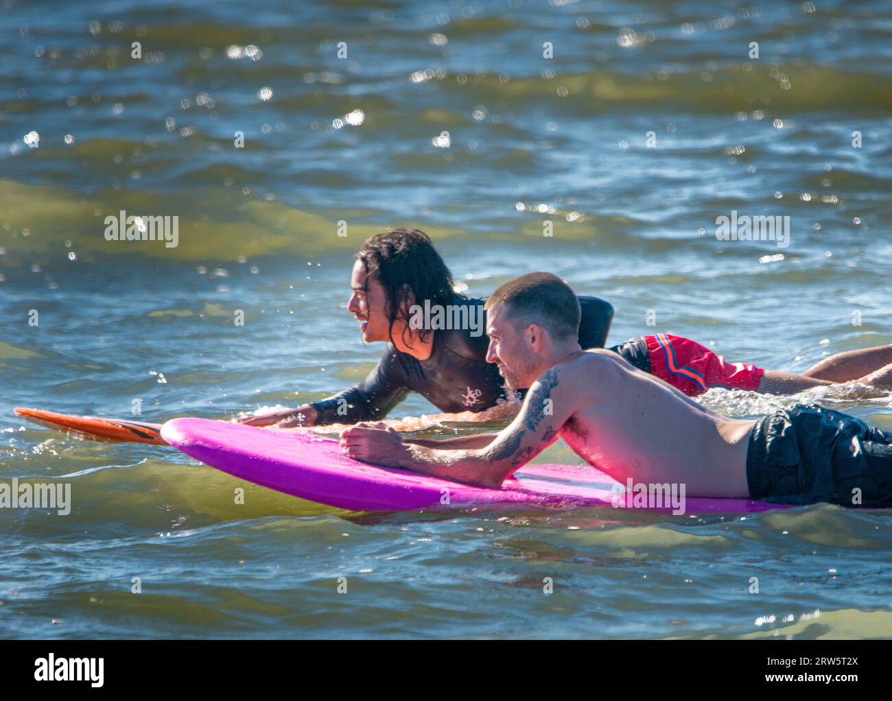 Cape May, Usa. September 2023. Surfer versuchen, einige Wellen zu reiten, die Überreste des Hurrikans Lee sind, während die Leute das warme Wetter am Samstag, den 16. September 2023 am Cove Beach in Cape May, New Jersey genossen. Die Temperaturen lagen am letzten Wochenende vor Herbst in den 80er Jahren. William Thomas Cain/Alamy Live News Stockfoto