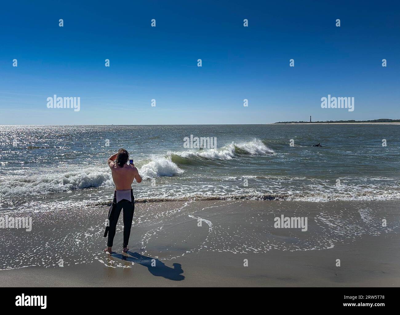 Cape May, Usa. September 2023. Surfer versuchen, einige Wellen zu reiten, die Überreste des Hurrikans Lee sind, während die Leute das warme Wetter am Samstag, den 16. September 2023 am Cove Beach in Cape May, New Jersey genossen. Die Temperaturen lagen am letzten Wochenende vor Herbst in den 80er Jahren. William Thomas Cain/Alamy Live News Stockfoto