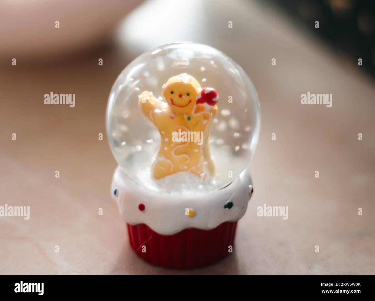 Lebkuchenmann im Wasserball mit Schneeflocken. Happy Holidays Concept. Hintergrund der Winterferien. Weihnachtsspielzeug. Wasserballon mit Schnee. Stockfoto