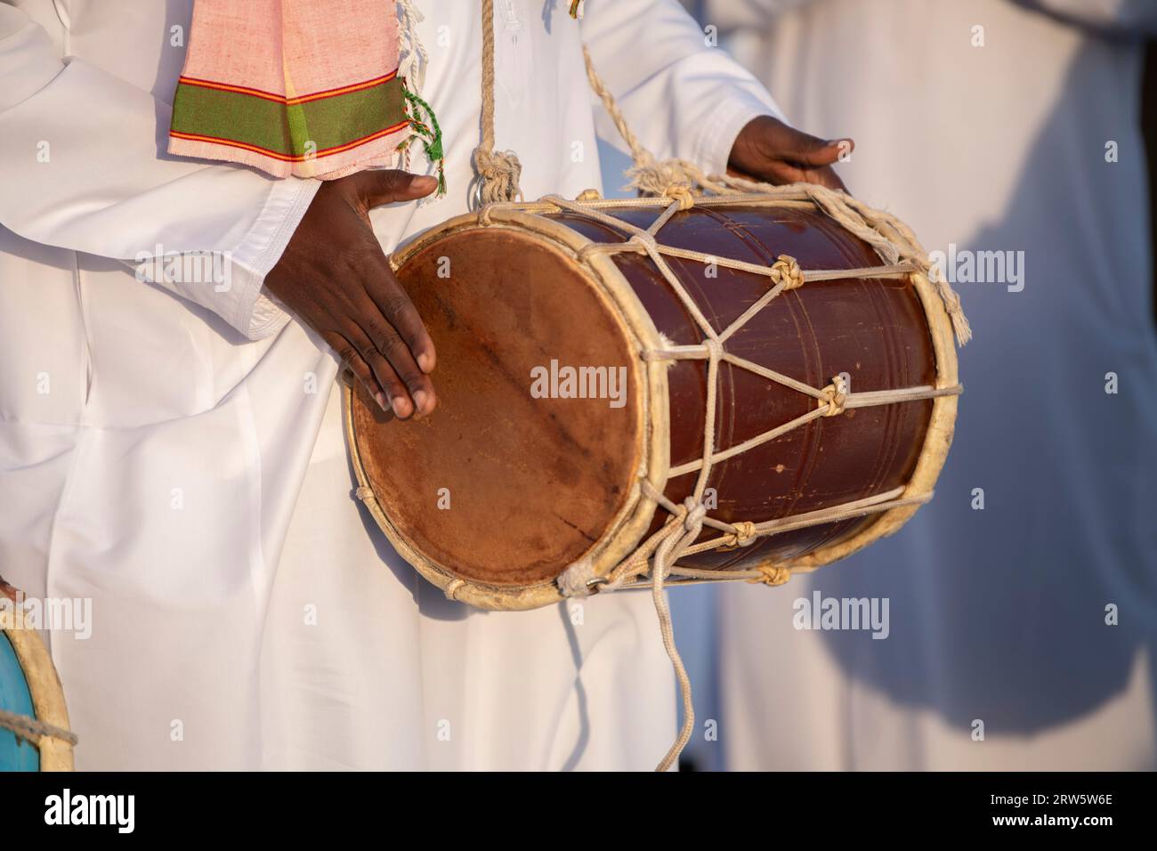 Nahaufnahme eines Musikers, der mit einem Dholak während eines Dhow-Festivals spielt. Stockfoto