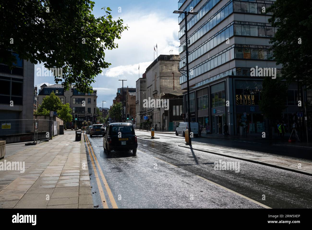 Schwarzes Taxi in Manchester, England nach einem Regenschauer im Sommer. Stockfoto