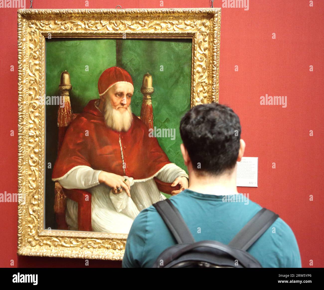 Ein Besucher, der das Gemälde Porträt von Papst Julius II. Des italienischen Renaissance-Malers Raphael in der National Gallery, London, Großbritannien, studiert Stockfoto