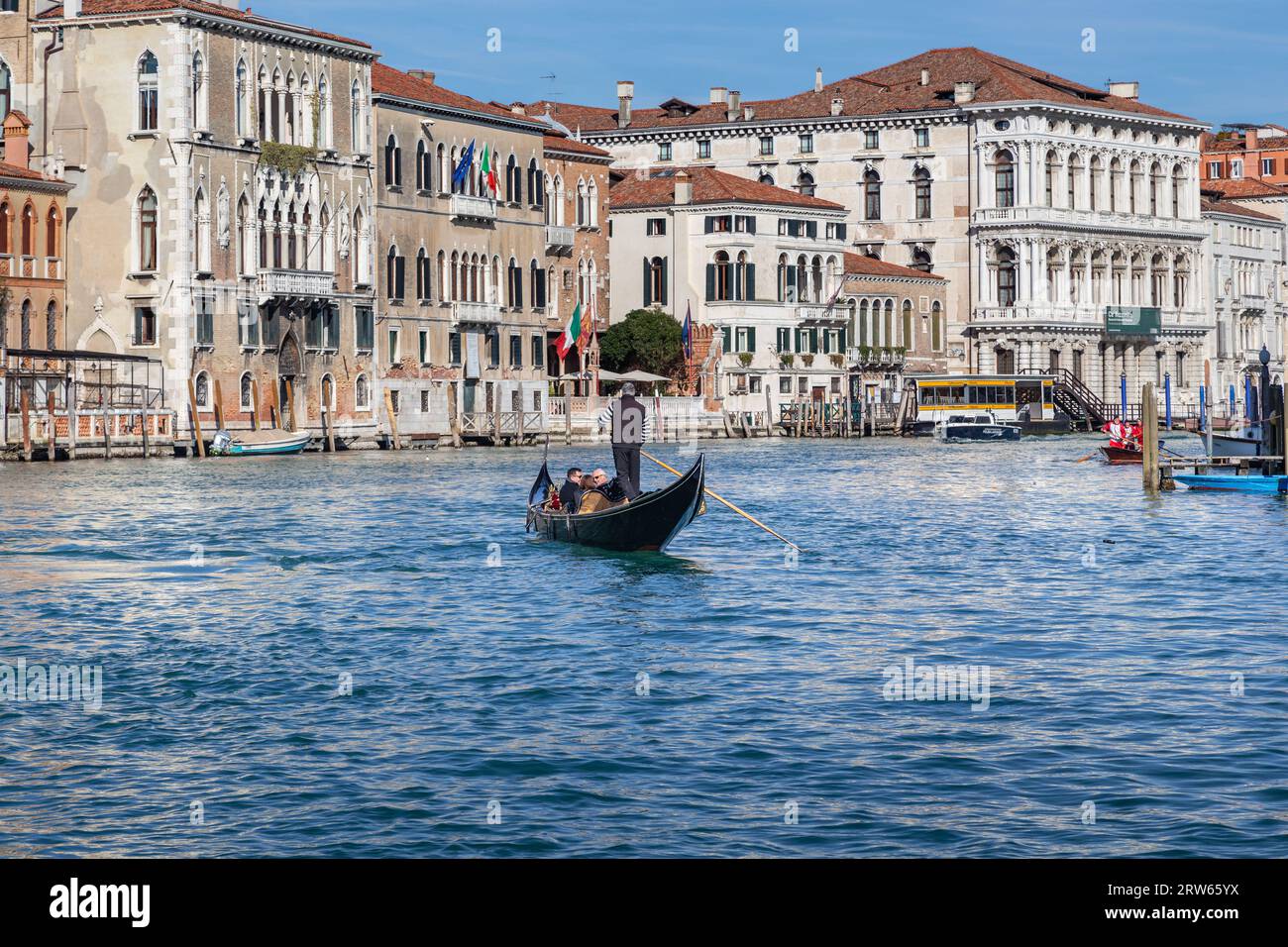 VENEDIG, ITALIEN - 12. MÄRZ 2023: Nicht identifizierte Urlauber machen eine Vergnügungsfahrt mit der Gondel entlang des Canal Grande. Stockfoto VENEDIG, ITALIEN - 12. MÄRZ 2023: Nicht identifizierte Urlauber machen eine Vergnügungsfahrt mit der Gondel entlang des Canal Grande. Stockfoto