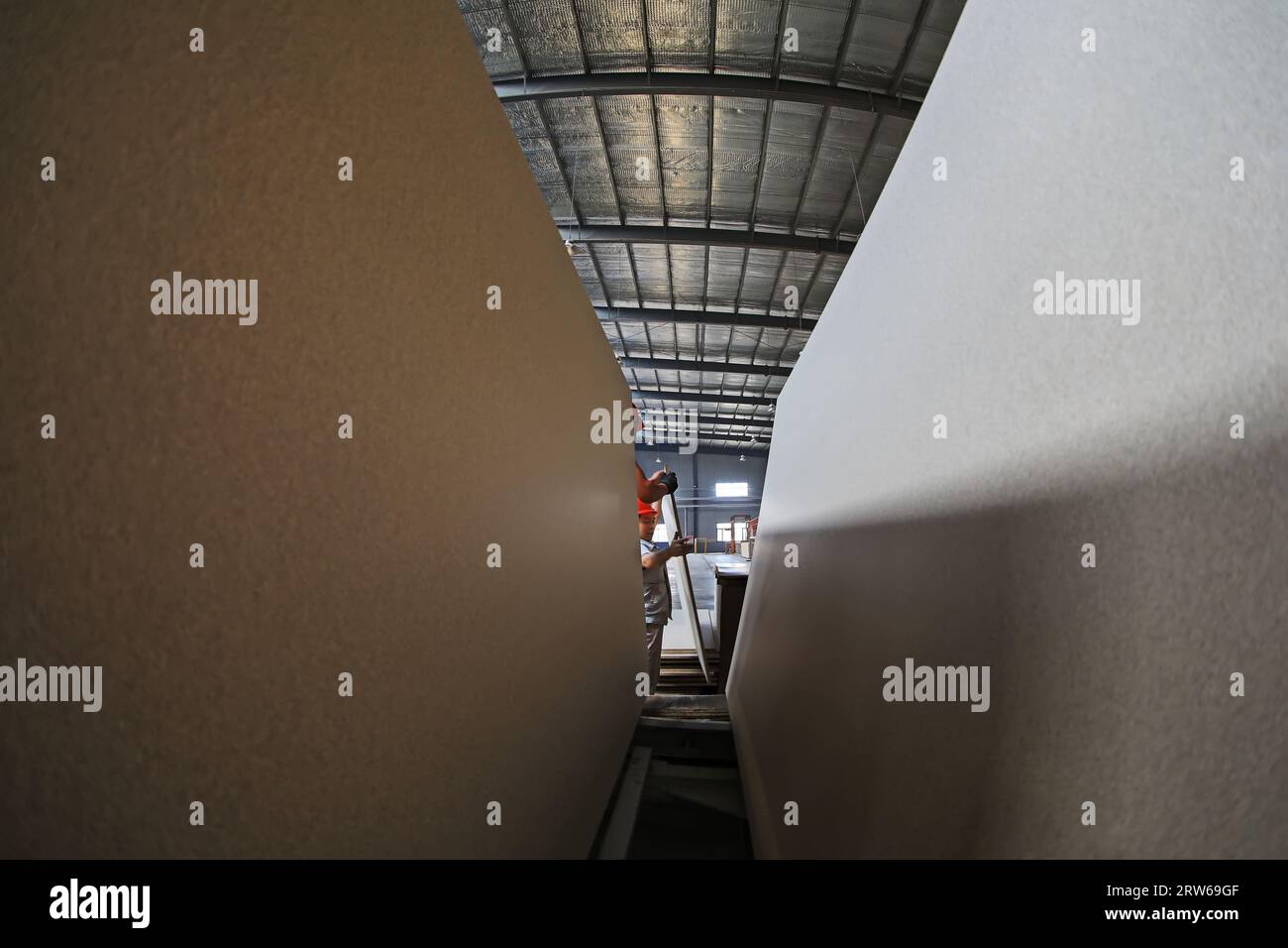 LUANNAN COUNTY, China - 9. August 2021: Techniker probieren die Qualität von Holzplatten in der Fabrik, China Stockfoto