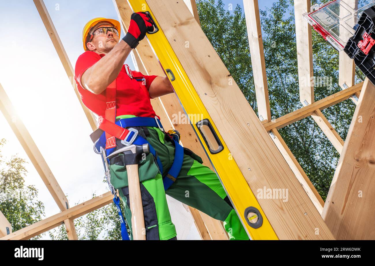 Kaukasischer Skelett-Gestellarbeiter mit großer Genauigkeit der Wasserwaage. Thema Bauindustrie. Stockfoto