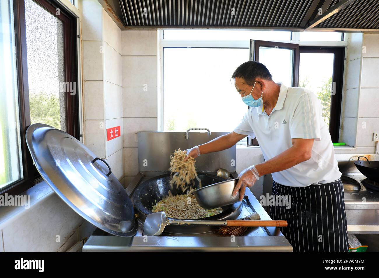 LUANNAN COUNTY, China - 7. September 2021：der Koch kocht in einem Landrestaurant in Nordchina Stockfoto