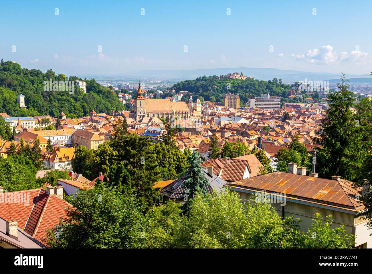 Panoramaaussicht auf Brasov am sonnigen Tag. Altes Stadtzentrum mit alten Gebäuden, grünen Hügeln und alten Türmen, Brasov, Rumänien Stockfoto