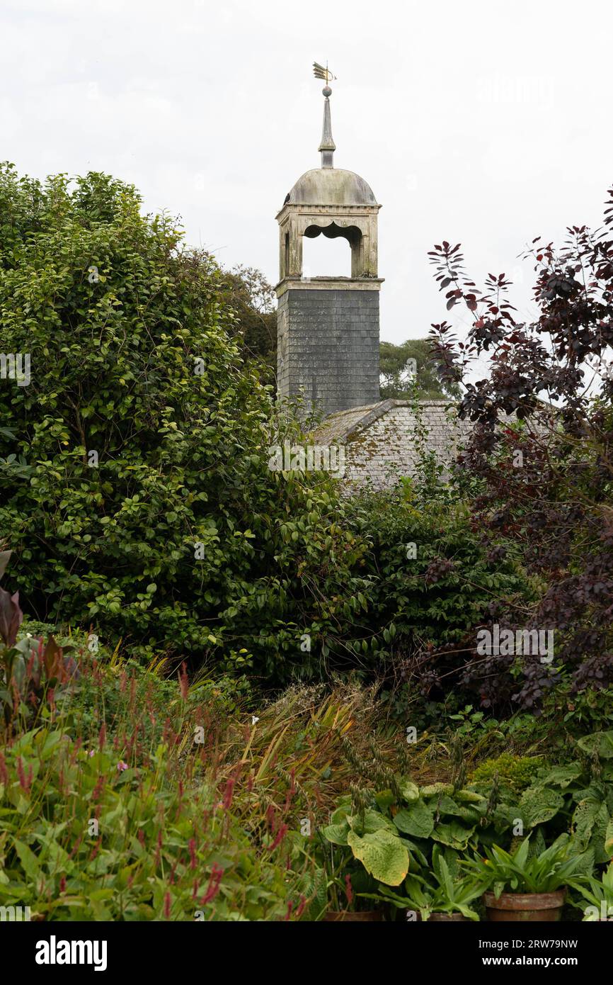 Historischer Kirchturm, der über dem üppigen kornischen Dorfgarten in Cornwall ragt Stockfoto