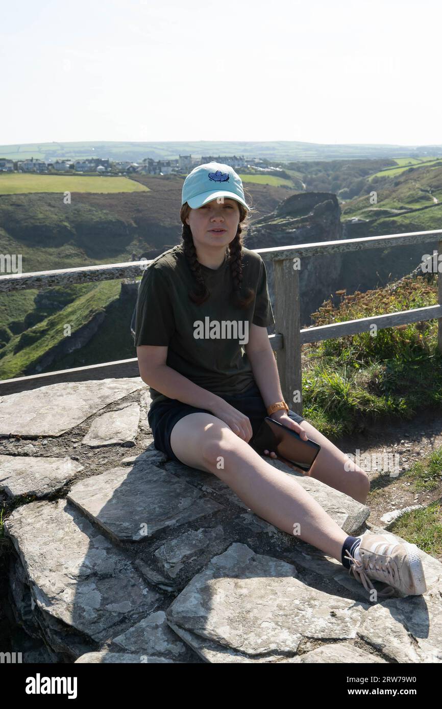 Junge Frau, die die malerische Landschaft Cornwalls vom Aussichtspunkt auf den Klippen aus genießt Stockfoto