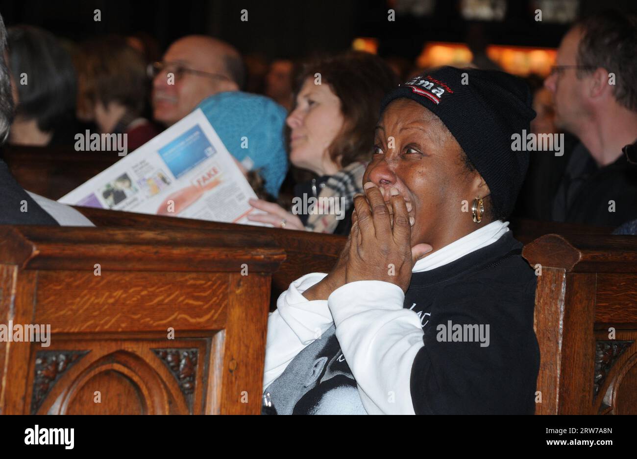In der Trinity Church in Manhattan sah eine Frau Barack Obamas im Fernsehen übertragene Amtseinführung als Präsident der Vereinigten Staaten und wurde von Emotionen überwältigt. Stockfoto