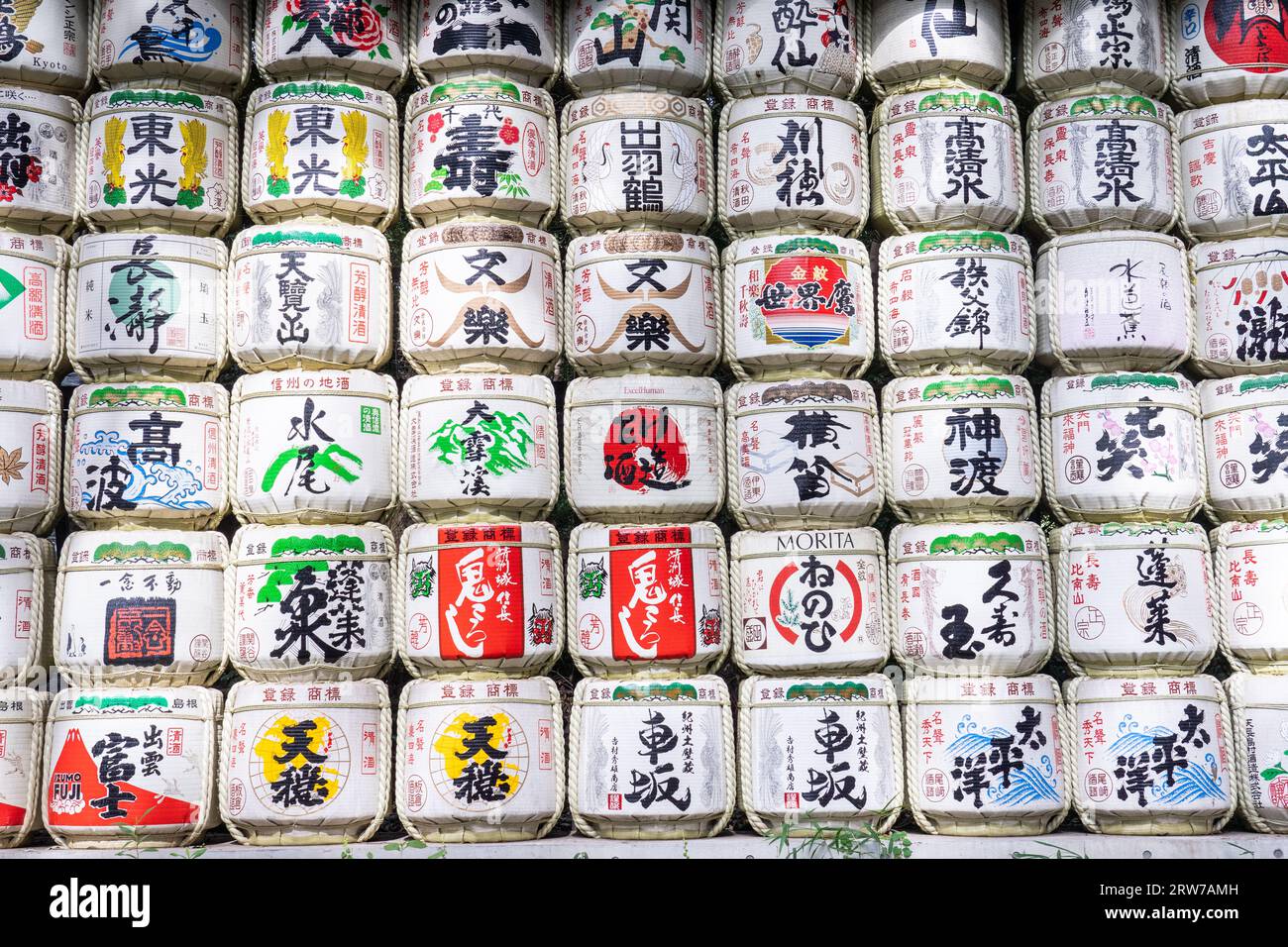 Stapel von bunten japanischen Sake-Fässern, die von Destillatoren am Südeingang des Meiji Jingu in einem 170 Hektar großen Wald in Shibuya, Tokio, Japan, gespendet wurden. Der Shinto-Schrein ist den Geistern von Kaiser Meiji und seiner Frau, Kaiserin Shoken, gewidmet. Stockfoto