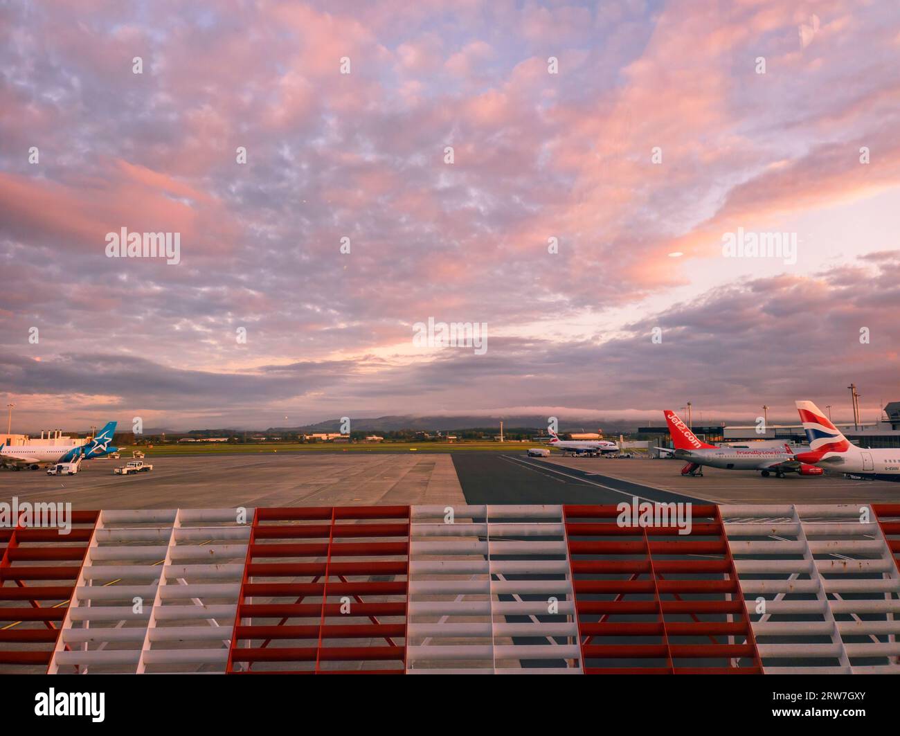 Ein farbenfroher Sonnenaufgang über dem Glasgow International Airport in Schottland Stockfoto