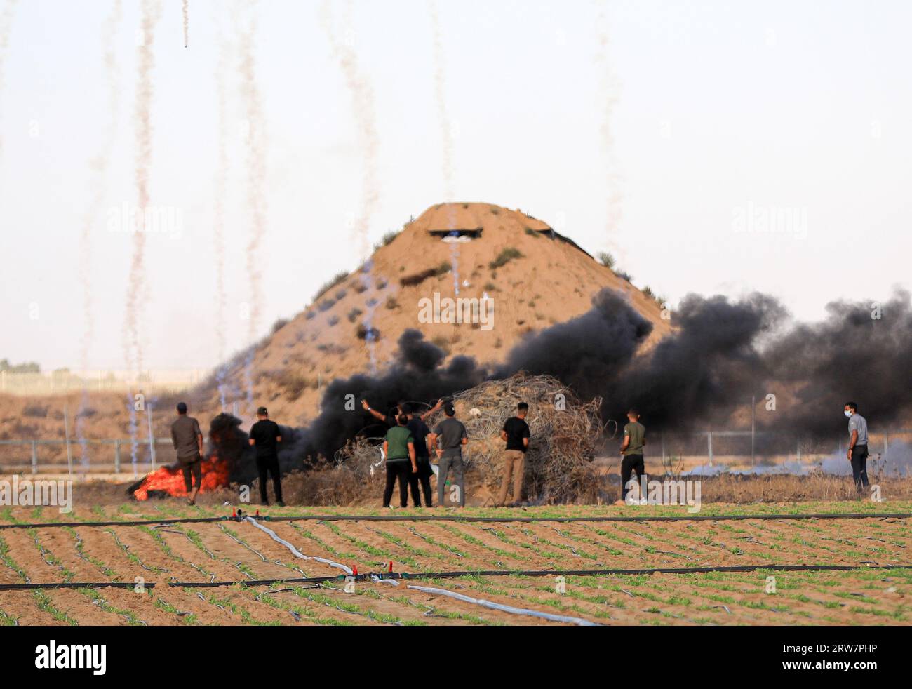 Palästinensische Demonstranten fliehen vor Tränengasbomben, die von israelischen Sicherheitskräften entlang der Grenze zu Israel, östlich von Khan Yunis, im südlichen Gazastreifen abgefeuert wurden. Stockfoto