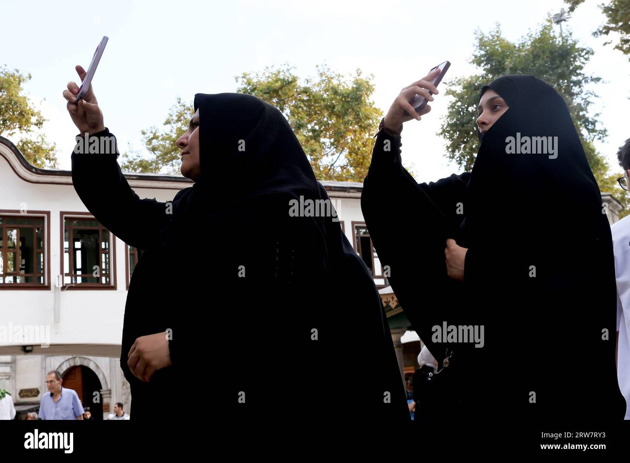 Muslimische Frauen, jede mit einer Burka, nehmen Selfies mit ihren Smartphones in der Eyüp Sultan Moschee in Istanbul, Türkei Stockfoto