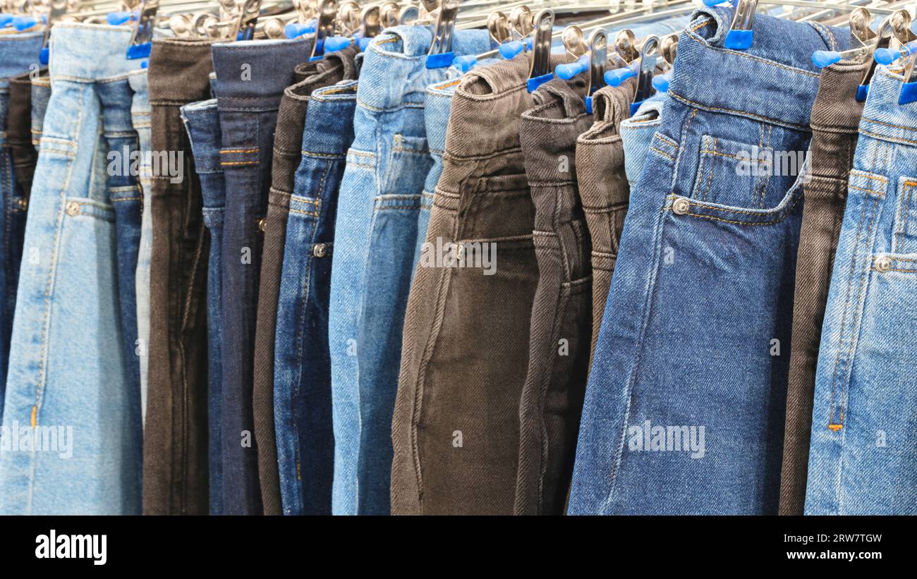 Blaue, schwarze und braune Jeanshose in einem Bekleidungsgeschäft Stockfoto