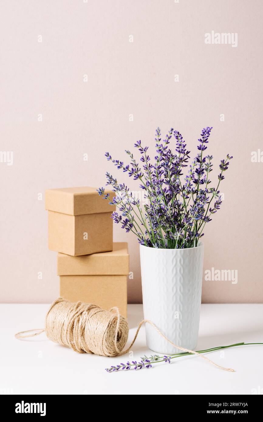 Lavendelstrauß in einer Vase, zwei kleine Geschenkschachteln und Jutefarbe, minimaler ökologischer Still. Stockfoto