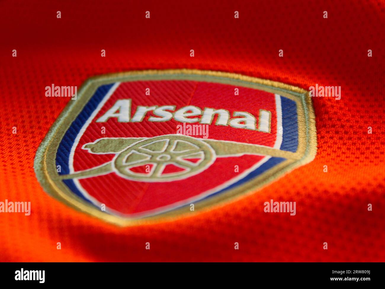 Ein Foto des rot-weißen Arsenal Football Club T-Shirts und des Abzeichens. Stockfoto