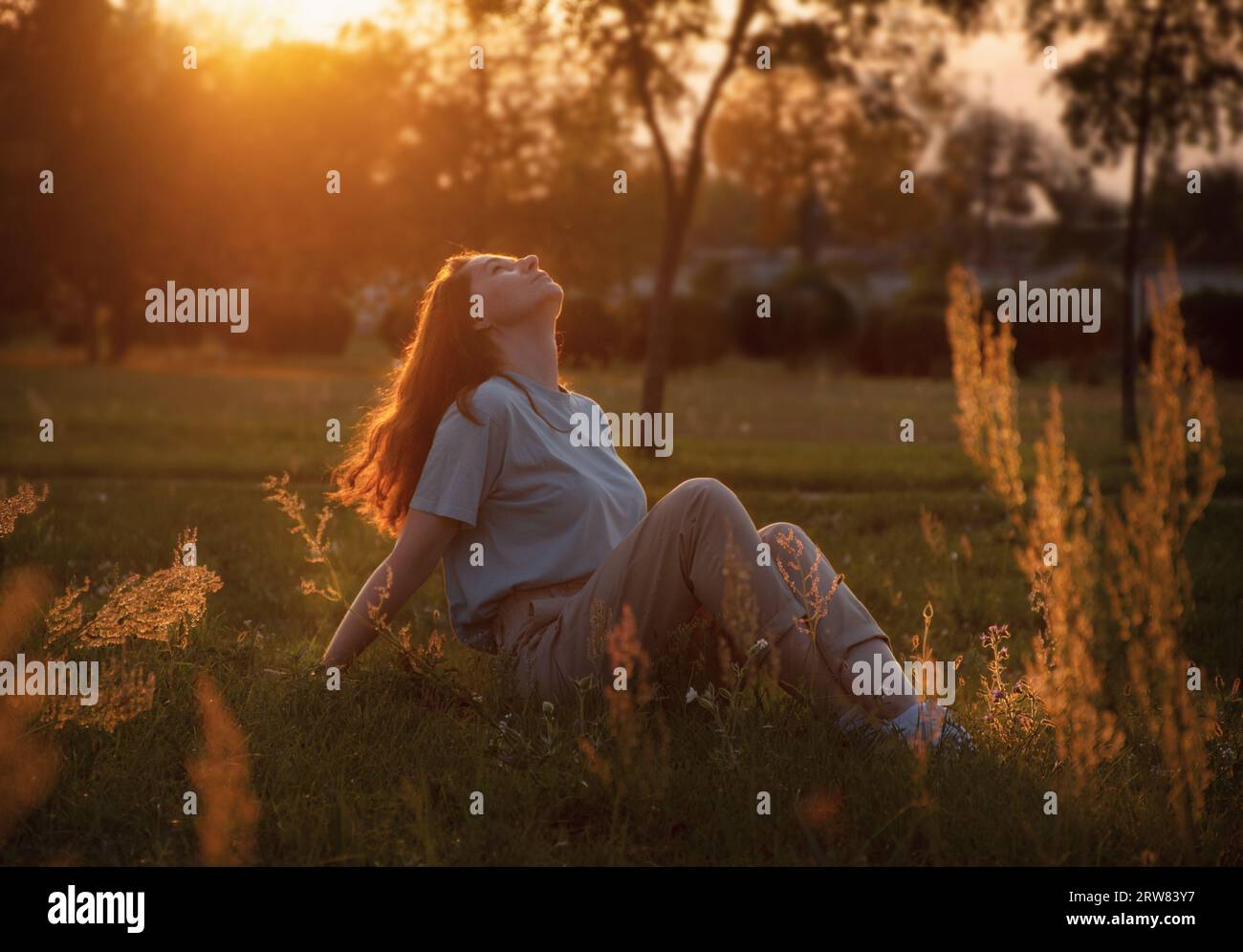 Eine Frau genießt den Sonnenuntergang und die Wärme, genießt das Leben. Stockfoto