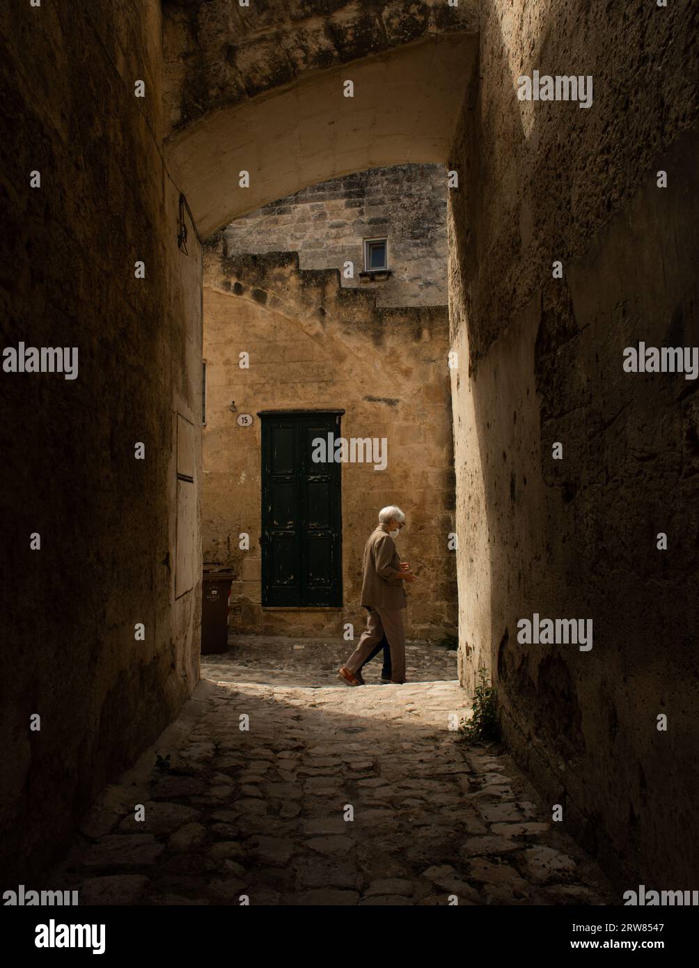 Älteres Paar, das im Sommer 2021 durch die Straßen von Matera in Süditalien spaziert und covid-Masken trägt Stockfoto
