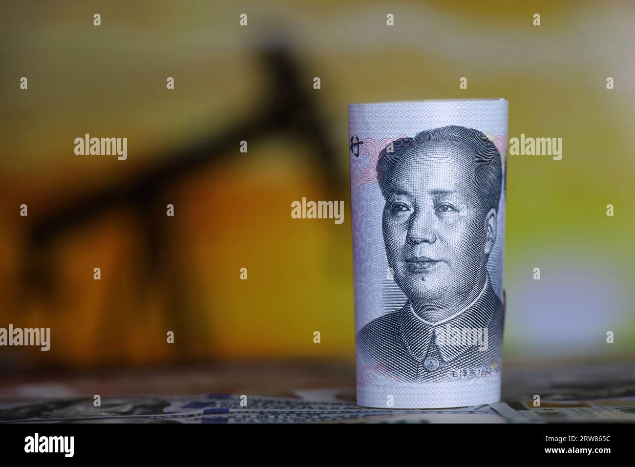 Chinesische Yuan-Banknote auf dem Hintergrund der Ölpumpenanlage. Konzept der Ölindustrie und der Preise Stockfoto