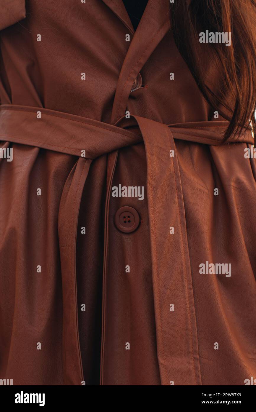 Modisches Damenoutfit für den Herbst. Elegantes braunes Mantelmaterial. Trendige moderne Kleidung. Street-Style-Mode Stockfoto