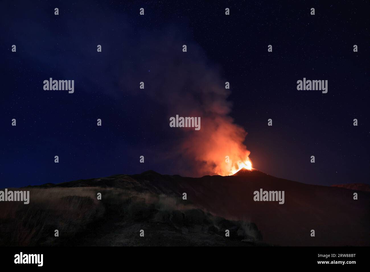 Etna e il suggestivo paesaggio di notte sul vulcano di Sicilia durante l'eruzione del 13 agosto 2023 sotto il cielo stellato nitido con fumo e vapore. Stockfoto