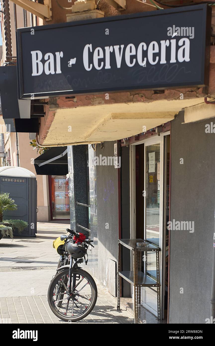Viladecans, Spanien - 17. September 2023: Brauerei-Bar mit einem Athletenfahrrad, das vor der Tür des Gebäudes geparkt wird. Stockfoto