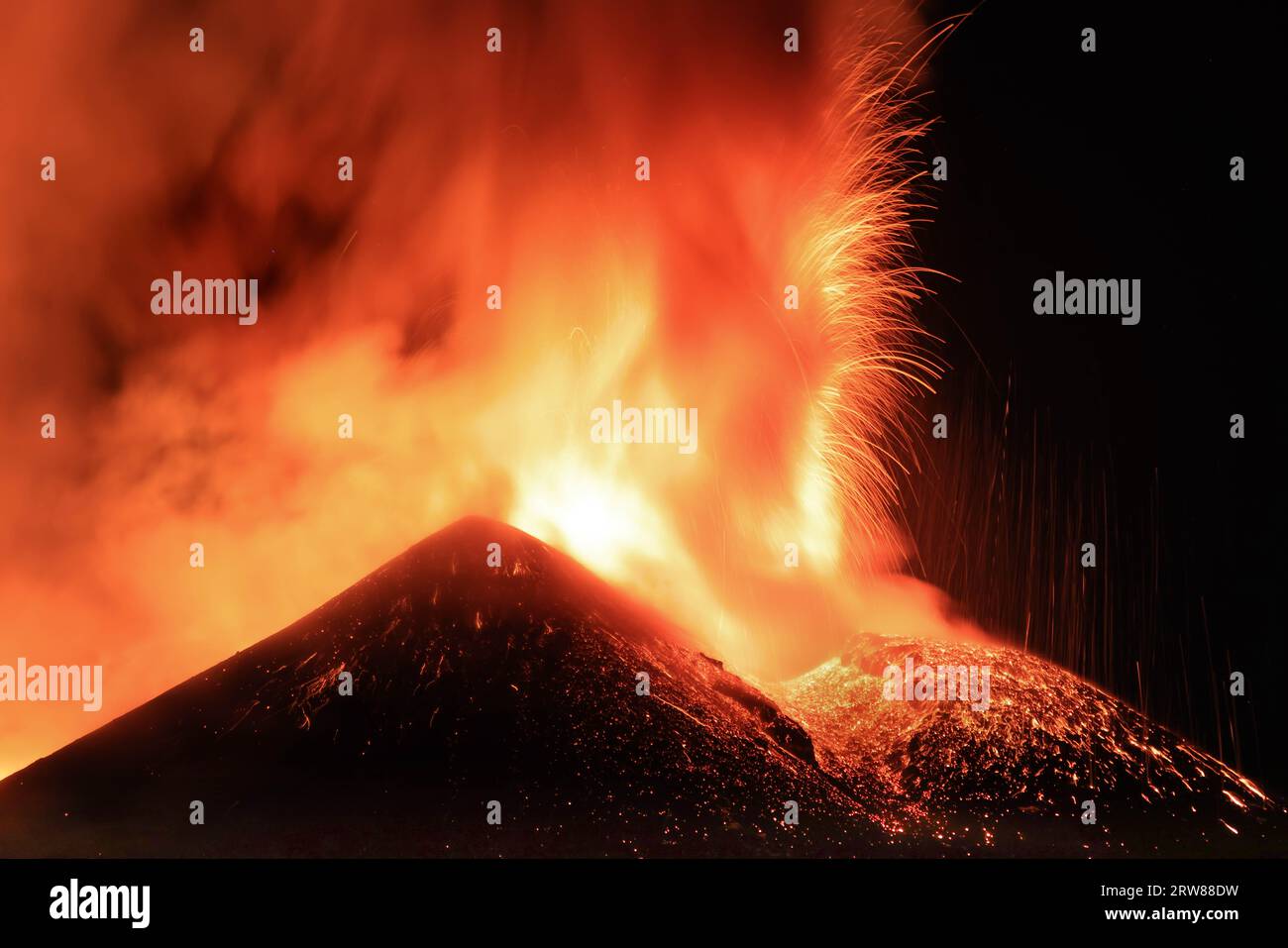 Ätna-Vulkan in Sizilien - Blick auf den Krater während einer gigantischen Lavaexplosion in der Nacht mit suggestivem Licht und Hintergrundlicht Silhouette des aktiven obersten Kraters Stockfoto