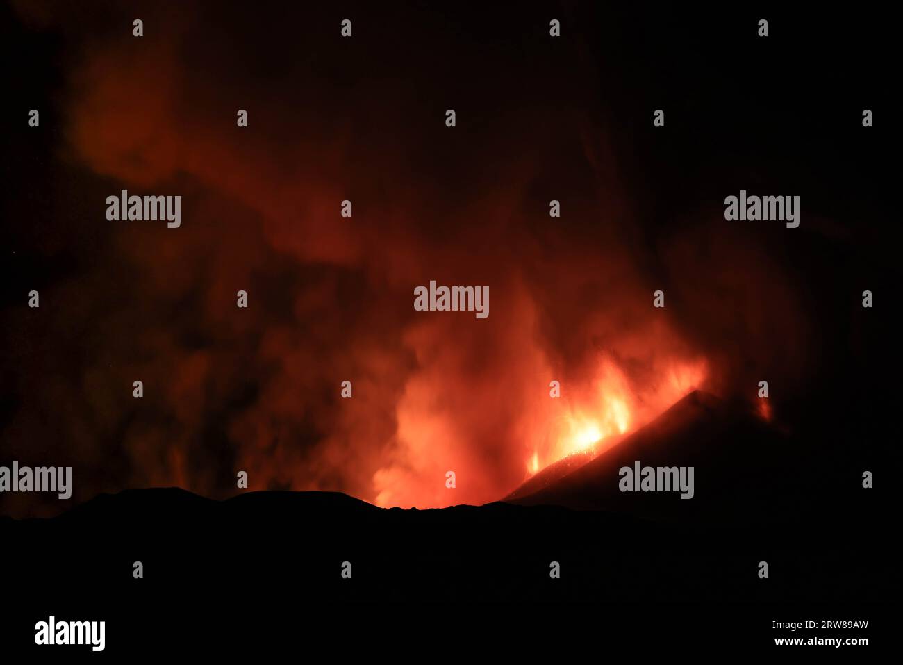Ätna während einer suggestiven Eruption in der Nacht aus dem Vulkankrater mit imaginären Gesichtern und Formen, die durch Rauchemissionen erzeugt werden. August 2023 Stockfoto
