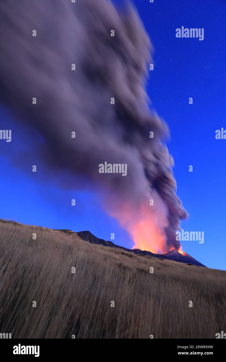 Ausbruch des Ätna-Vulkans bei Sonnenaufgang mit großen Ascheemissionen aus dem Krater mit blauem Himmel im Hintergrund; 13. August 2023 Stockfoto