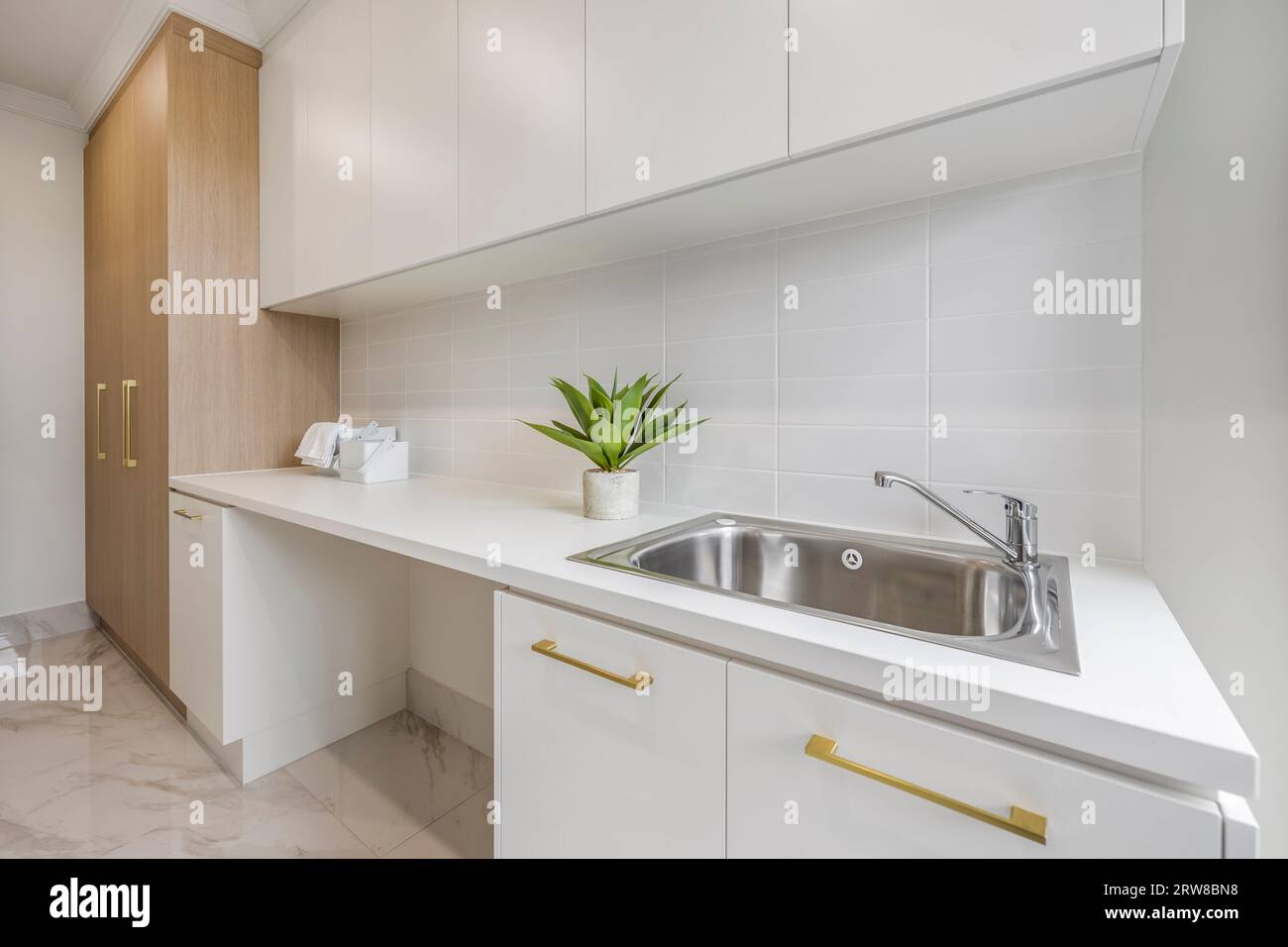 Wäscherei mit gefliestem, einfachem Waschbecken Stockfoto