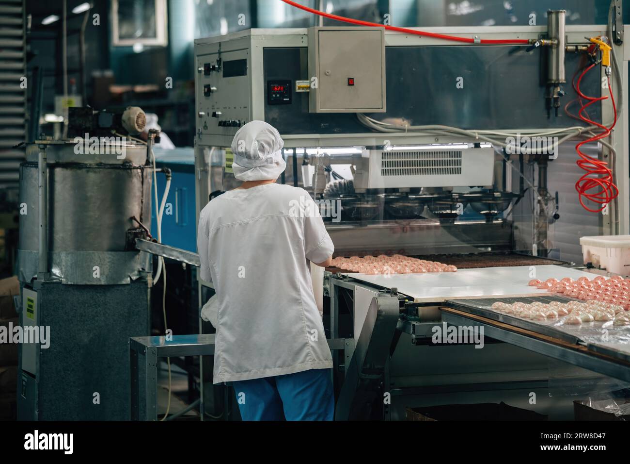 Die Konditorei arbeitet an der Marshmallow-Produktionslinie. Stockfoto