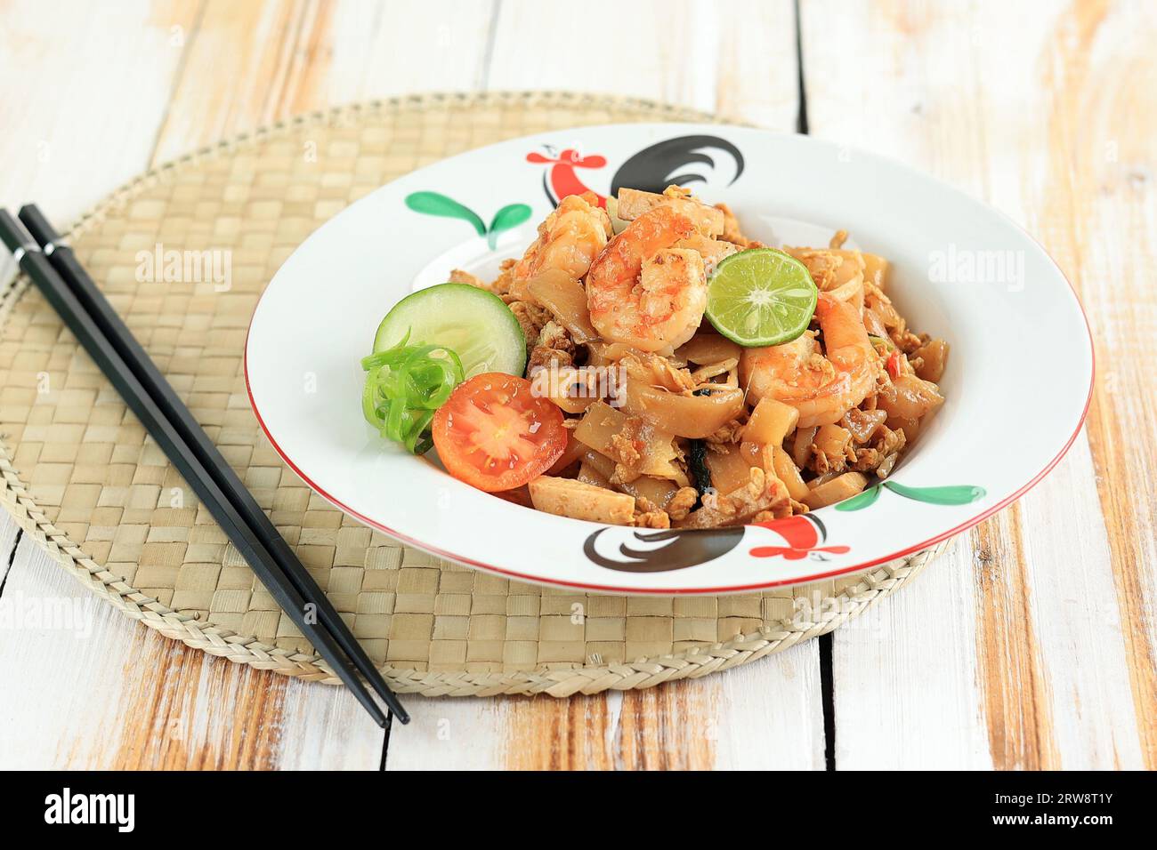 Meeresfrüchte Kwetiau Goreng mit Ei, Garnelen, Fischfleischbällchen und Limette. Gebratenes Char Kway Teow mit Garnele auf weißem Tisch Stockfoto