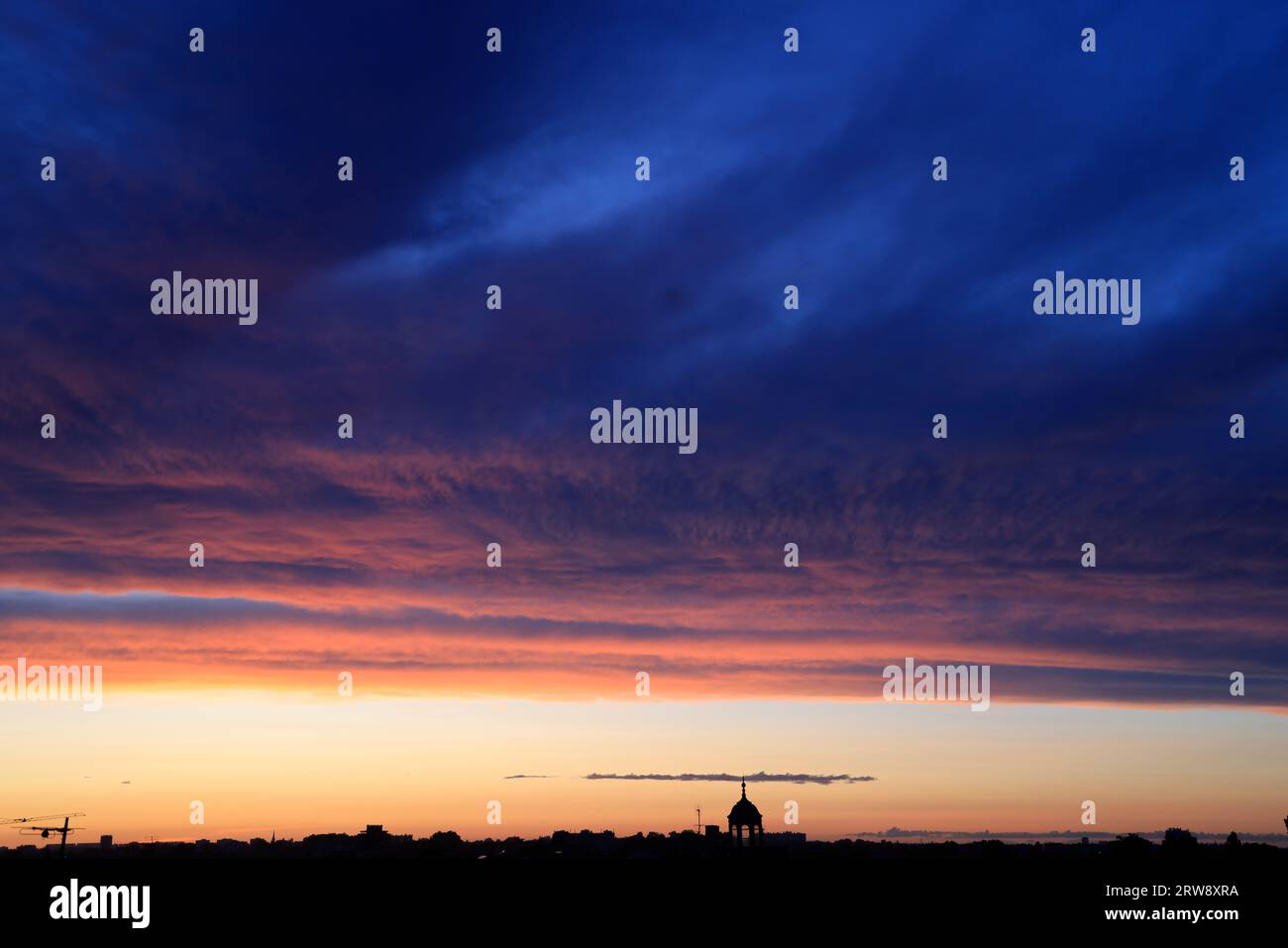 Untergehende Sonne, Sonnenuntergang, mit bunten und bedrohlichen Wolken am Himmel über der Stadt. Bordeaux, Gironde, Frankreich, Europa. Foto: Hugo Martin. Stockfoto