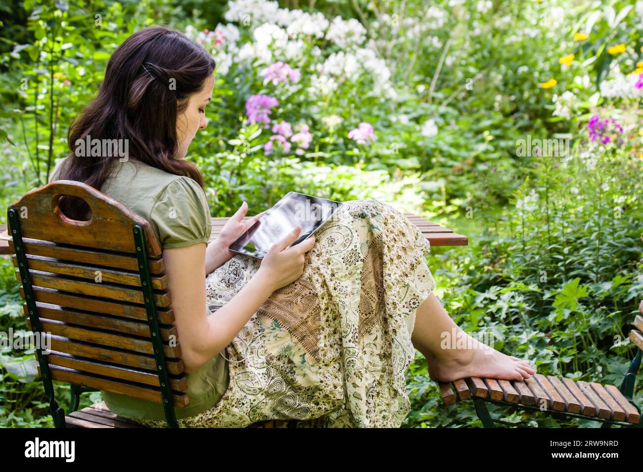 Junge Frau mit Tablet-PC im Garten, junge Frau mit Tablet-PC im Garten Stockfoto